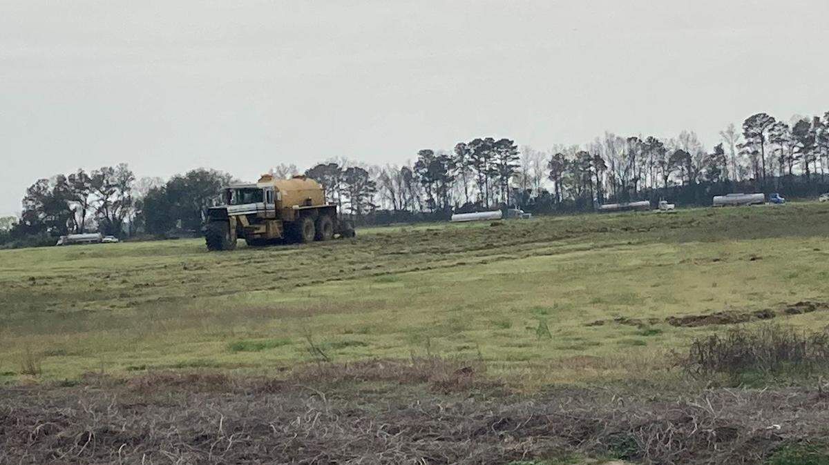 Heavy machinery spreads sludge on a field in Darlington County, SC. Photo taken March 2023.