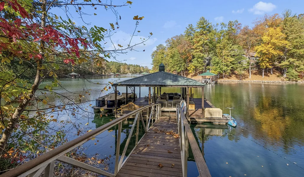 The property has a covered dock and comes with a 2019 Bennington Tritoon pontoon boat.