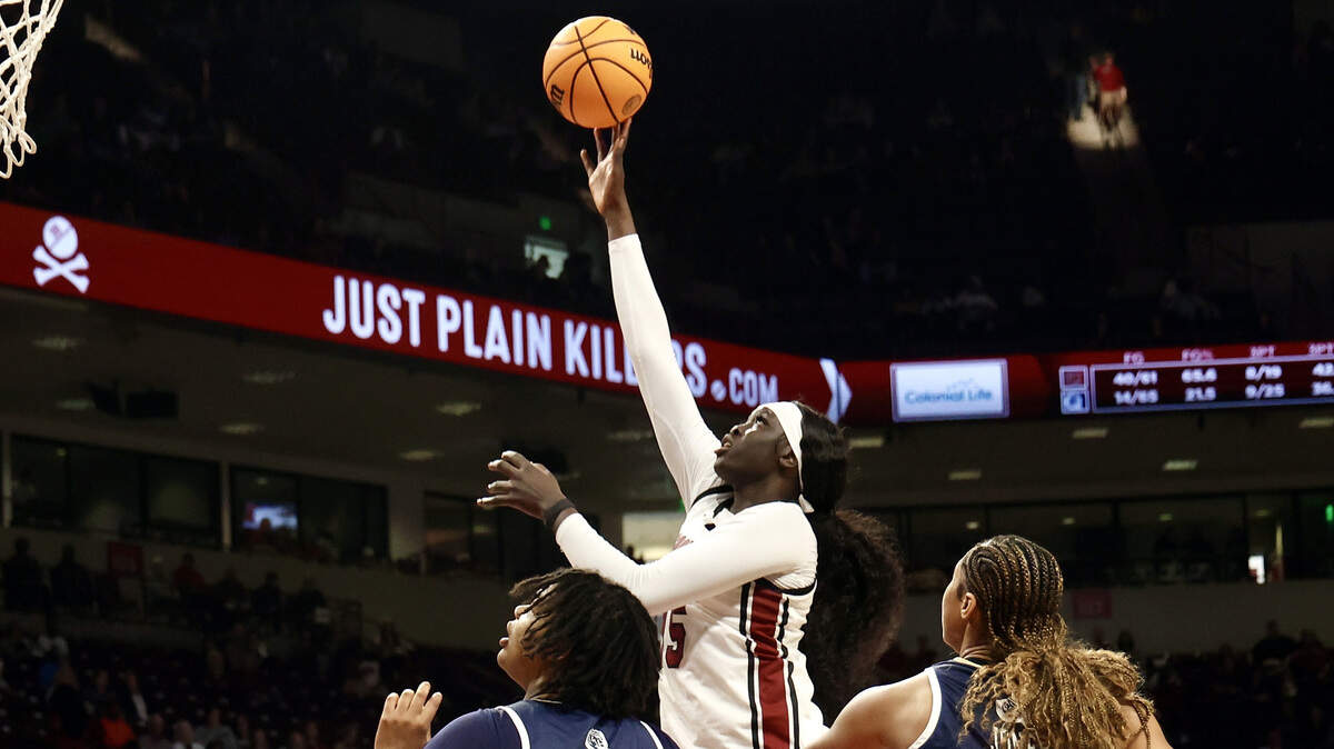South Carolina’s Adhel Tac shoots as Queens’ Breah Franks (31) and Brenae Jones-Grant defend during their game Sunday at Colonial Life Arena.