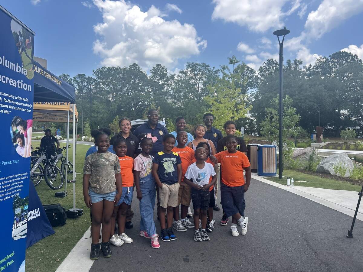 Officer poses with 12 kids.