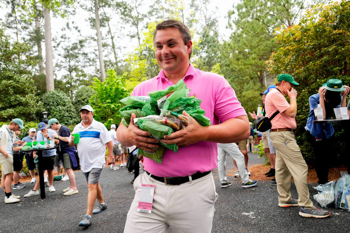 Chase Abbott of Augusta, Ga., carries 18 sandwiches during a practice round Tuesday for The Masters golf tournament at Augusta National Golf Club. Abbott said he bought one sandwich for each hole and it cost him just over $40.