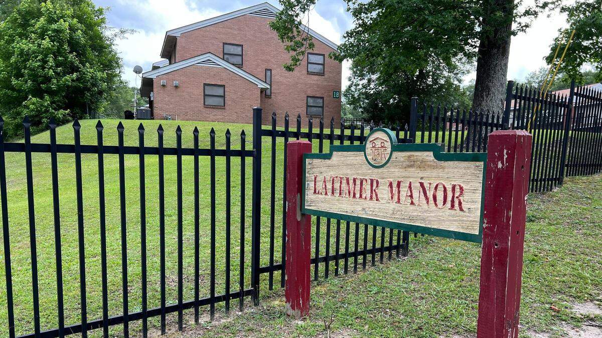 An exterior photo of a sign outside the apartment complex Latimer Manor.