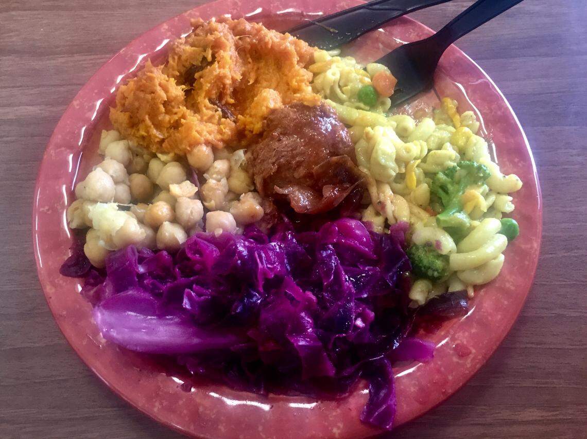 A plate of vegan soul food from Lamb’s Bread Returns The King, featuring sweet potato souffle, “goddess mac,” purple cabbage, chickpeas and a “chicken” nugget.