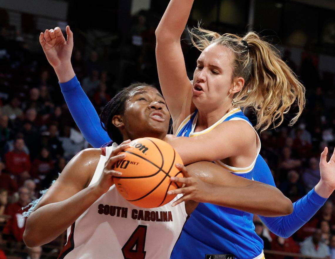 UCLA’s Emily Bessoir (11) pressures South Carolina’s Aliyah Boston (4) under the basket during the first half of action in the Colonial Life Arena on Sunday, Nov. 29, 2022.