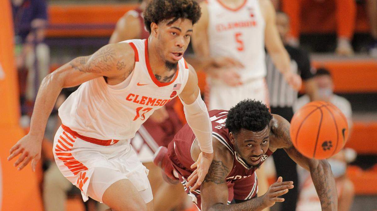 Clemson guard David Collins (13) and South Carolina guard Jermaine Couisnard (5) chase after a loose ball during the game Saturday at Littlejohn Coliseum.