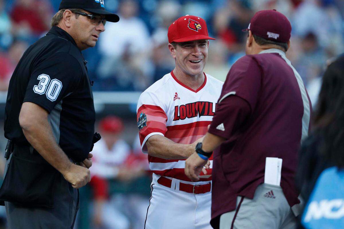 Jun 20, 2019; Omaha, NE, USA; Louisville Cardinals head coach Dan McDonnell greets Mississippi State Bulldogs head coach Chris Lemonis as home plate umpire Jeff Hinrichs looks on prior to the game in the 2019 College World Series at TD Ameritrade Park.