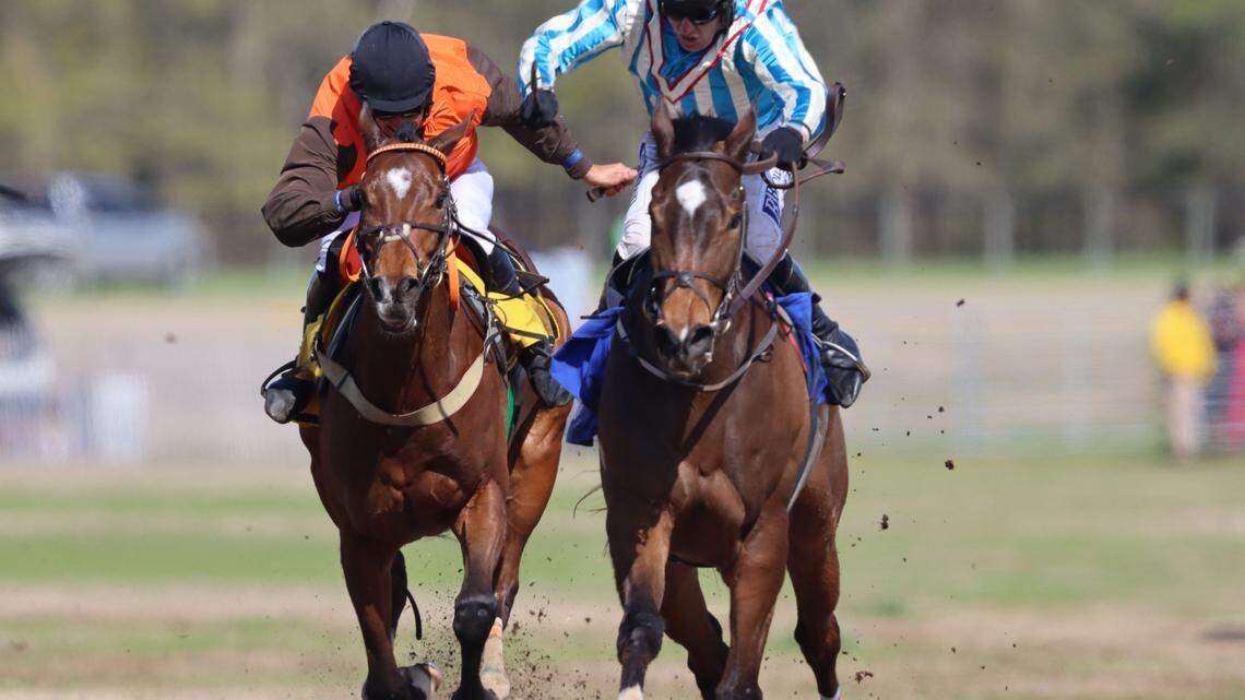 In the final stretch, jockey David England prepares to overtake Graham Watters in order to win the race in the 88th Running of the Carolina Cup on April 1, 2023.