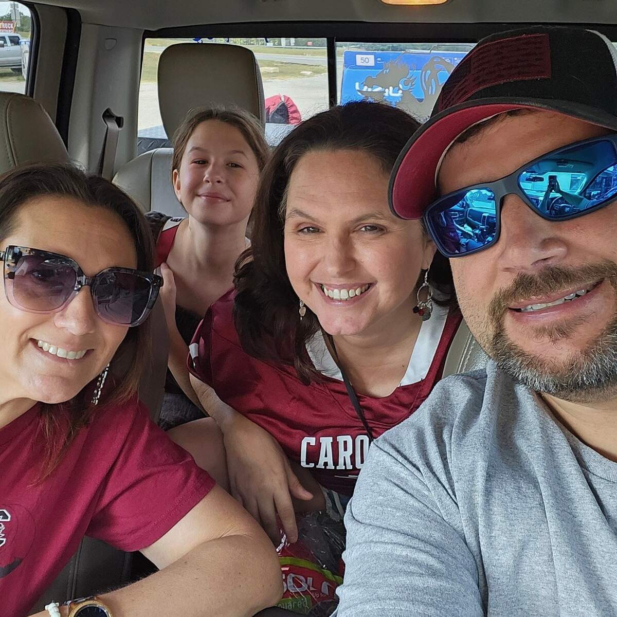 Wearing the jersey Reed bought her, Tonya (second from right) and her daughter, Elise (back left), head to the USC-Akron game with Brad and Betsy Polin.