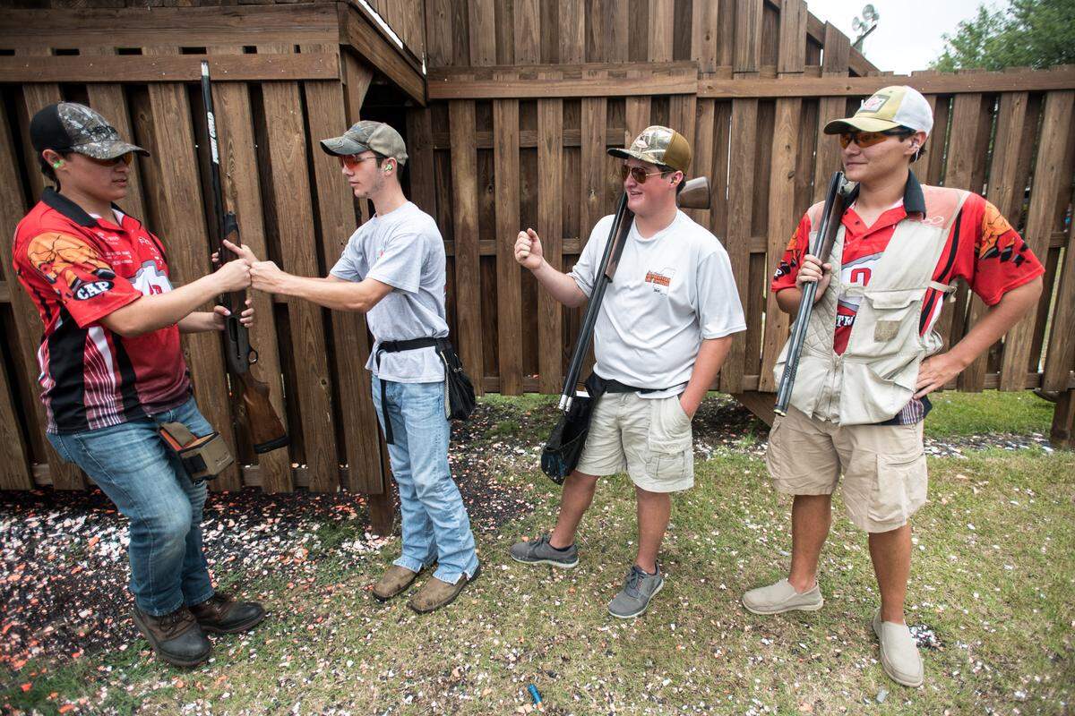 Zack Felkel of Orangeburg Prep, left, exchanges fist bumps with teammates Cooper Gleaton, Matthew Zeigler, Jace Hiers, and Zack Felkel at the Mid-Carolina Gun Club during the South Carolina State High School Clay Target League championships Saturday, June 8, 2019, in Orangeburg, S.C.