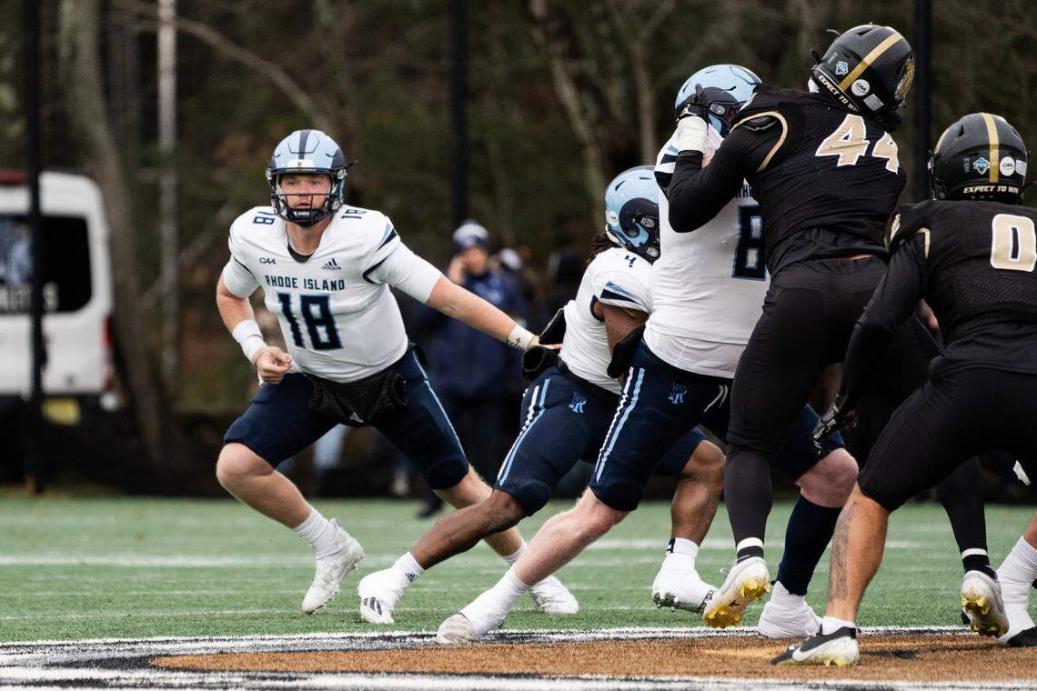 Former Clemson and current Rhode Island quarterback Hunter Helms hands the ball off during a 2024 game against Bryant