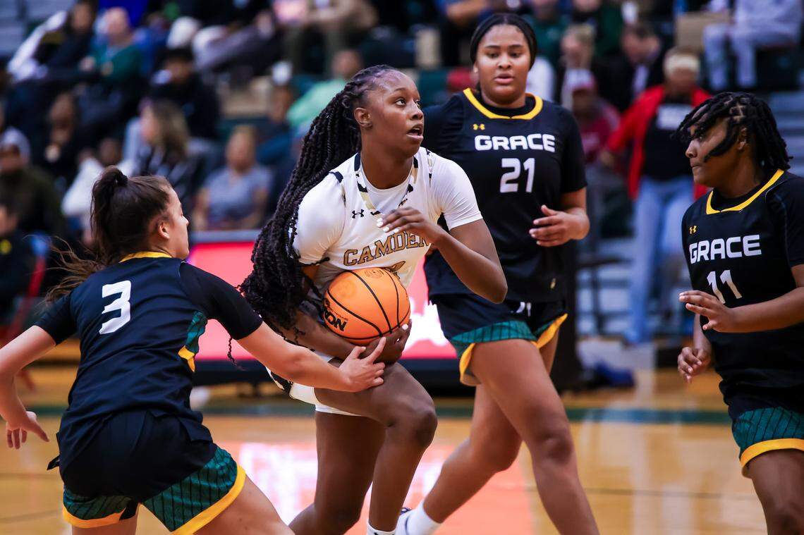 Camden Bulldogs Joyce Edwards (12) drives past Grace Christian Lions guard Isa Roman (3) at the Chick-fil-A Classic at River Bluff High School Wednesday, Dec. 27, 2023.