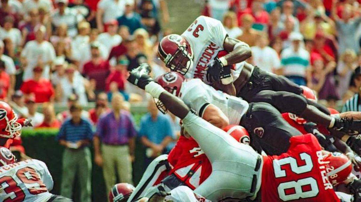 South Carolina running back Brandon Bennett leaps over the top of the Georgia defense to score a touchdown with time running out in their 1993 classic game in Athens.