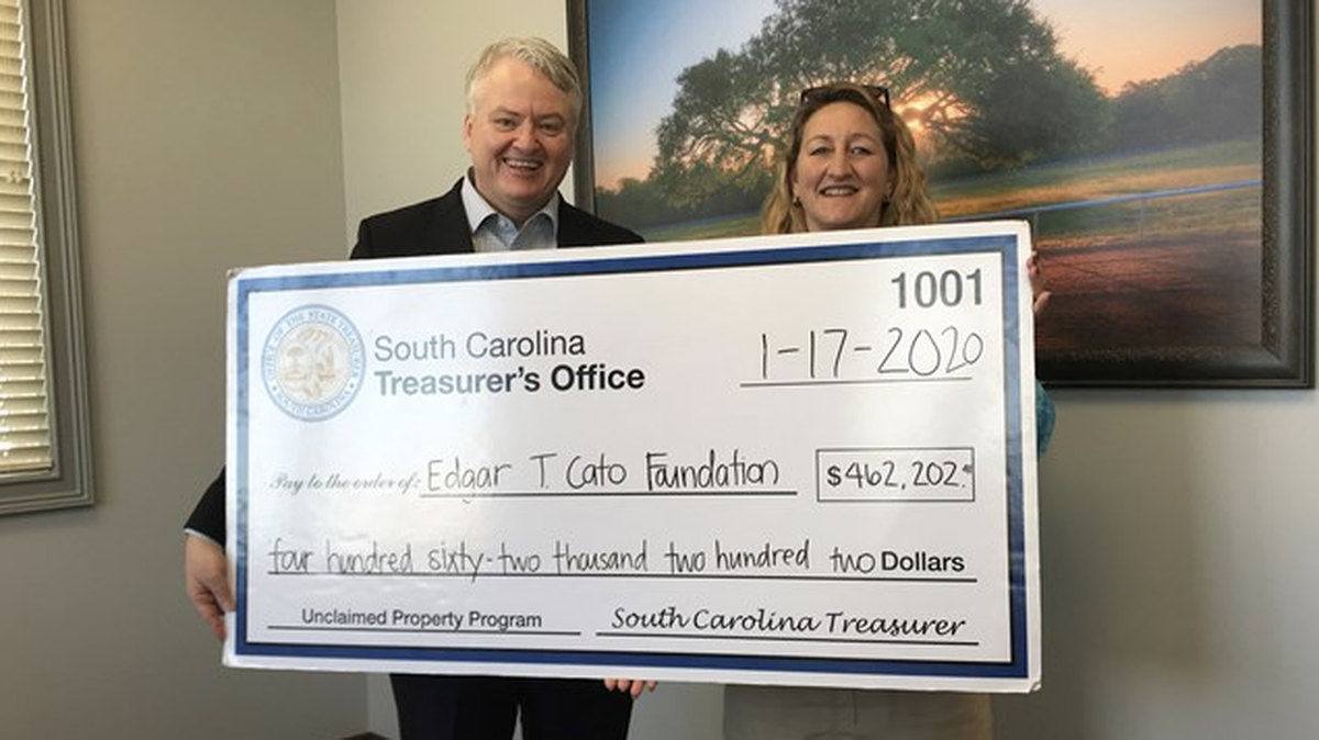 Treasurer Loftis presents an unclaimed property check to Christine Cato.