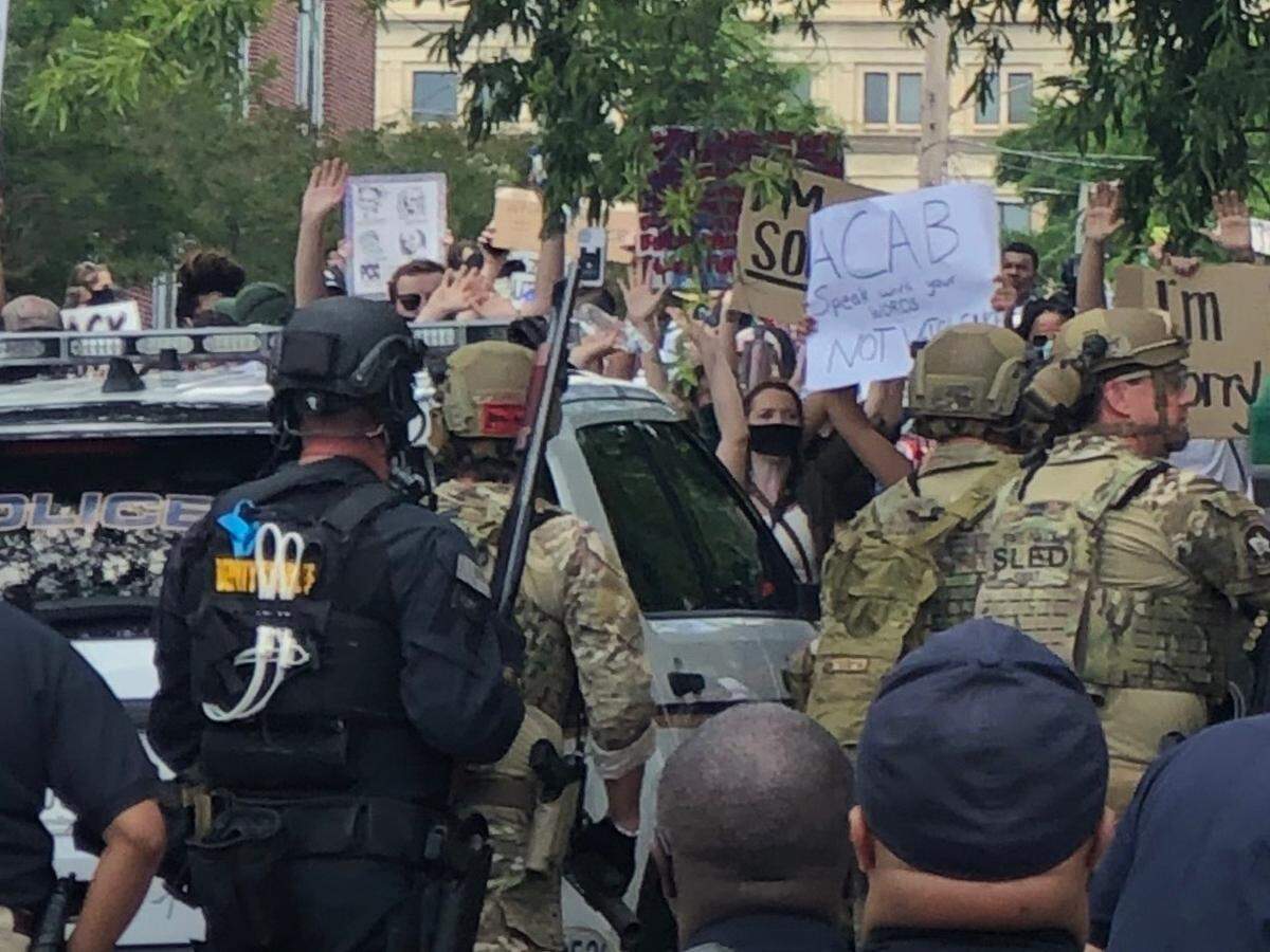 A sheriff’s department spokesperson sent a photo of a person in a crowd with their hands up, holding a water bottle. The sheriff said people threw objects at police before a confrontation with protesters on May 31. Protesters refute that.