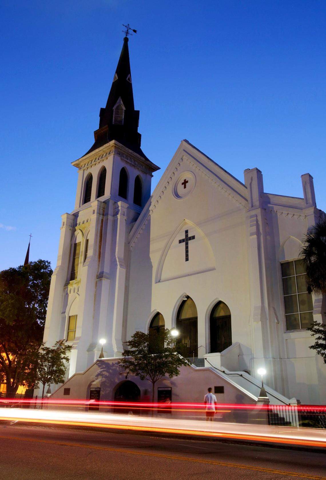 A visitor can be seen in front of Mother Emanuel AME Church as lights from cars driving past the building are captured as the sun fades, Friday, June 10, 2016.