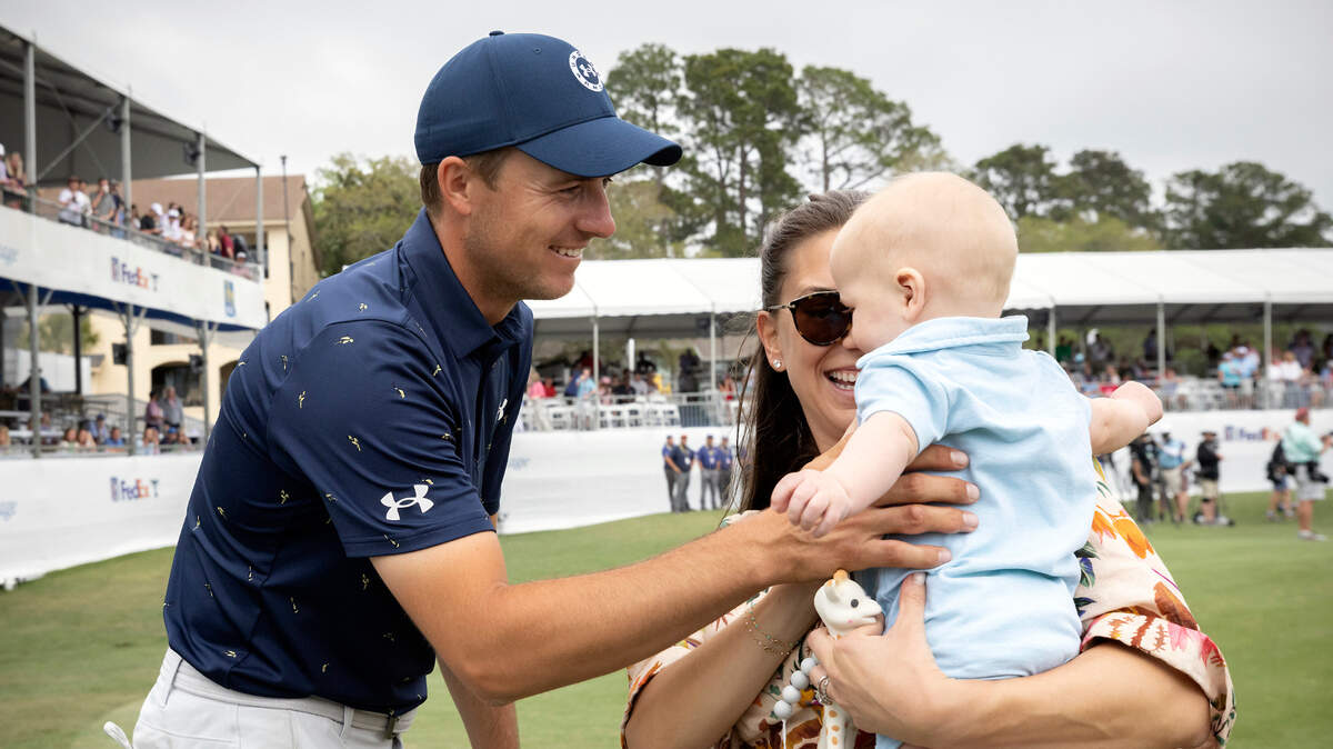 Jordan Spieth, left, greets his wife, Annie Spieth, and baby Samual on the 18th green after winning a one-hole playoff in the final round of the RBC Heritage golf tournament on April 17, 2022.
