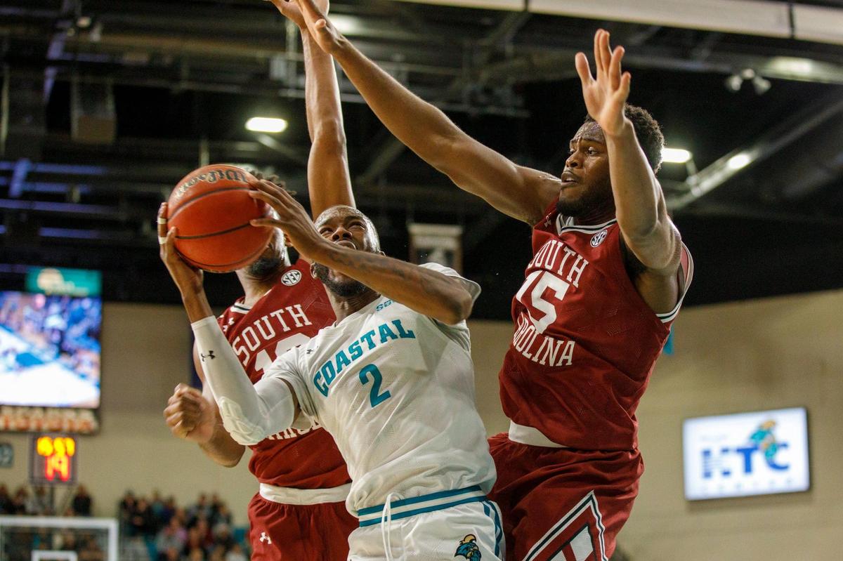Coastal’s Garrick Green gets fouled under the boards by South Carolina defenders. The Coastal Carolina Chanticleers of the Sun Belt Conference hosted the South Carolina Gamecocks of the SEC in college basketball Wednesday night at the HTC Center in Conway, SC for the first time. Dec. 1, 2021.