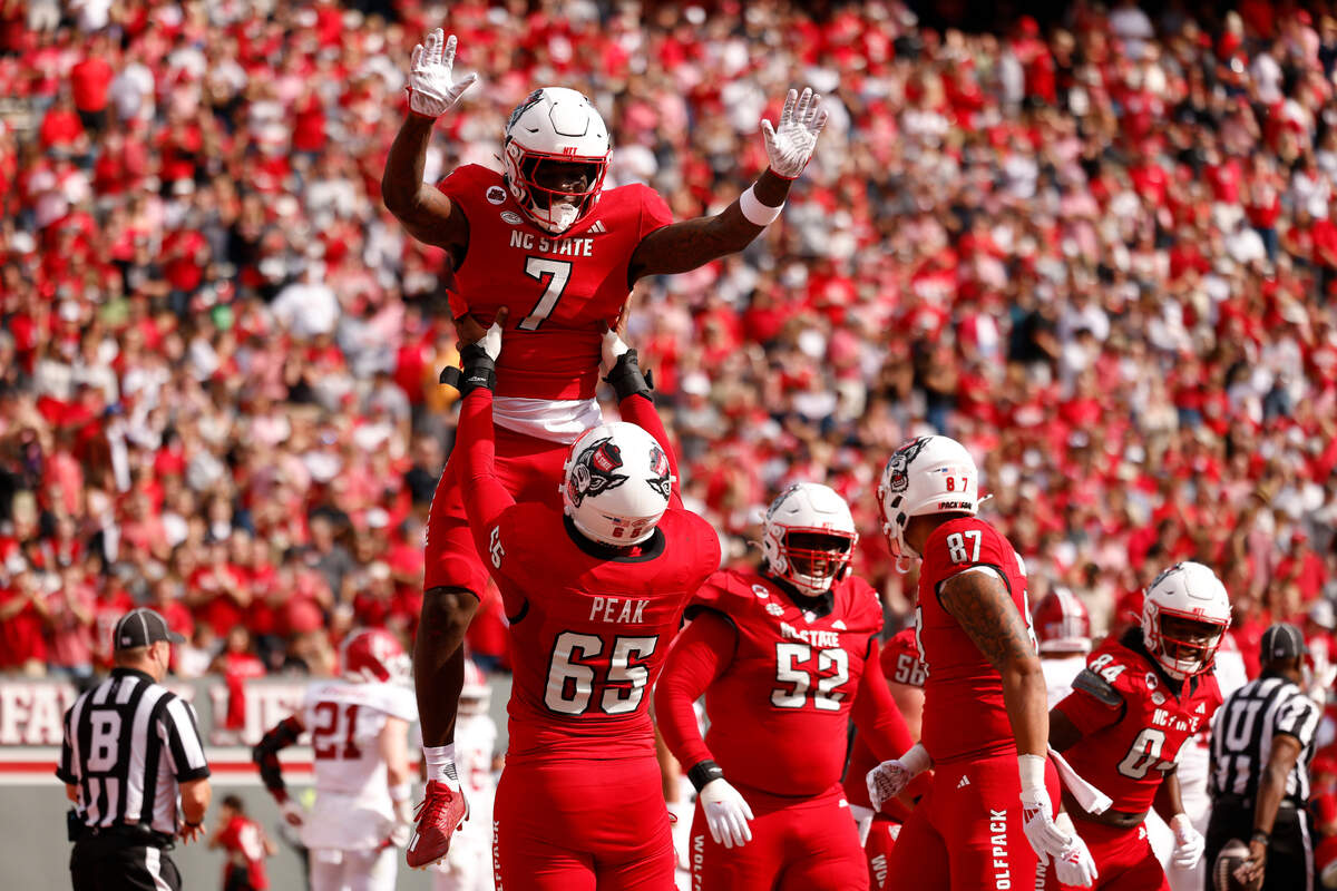 Jordan Waters #7 of the NC State Wolfpack celebrates his touchdown with teammate Jacarrius Peak #65 during the first half of the game against the Stanford Cardinal November 2, 2024.