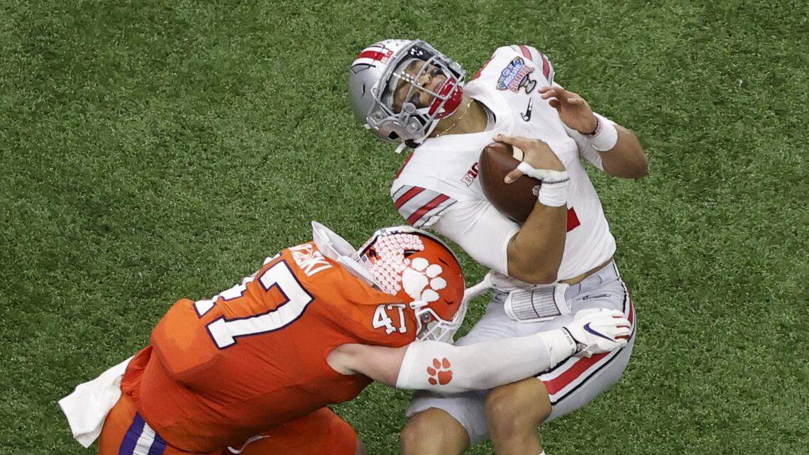 Ohio State quarterback Justin Fields gets hit by Clemson linebacker James Skalski during the first half of the Sugar Bowl NCAA college football game Friday, Jan. 1, 2021, in New Orleans. Skalski was ejected from the game for targeting.(AP Photo/Butch Dill)