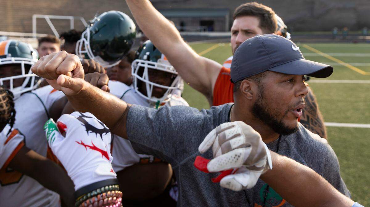Head coach DeMarcus Simons calls a huddle during practice at Eau Claire High School on Tuesday, August 22, 2023.