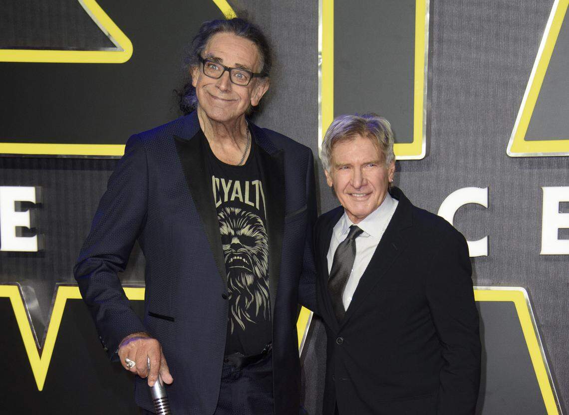 FILE - This Dec. 16, 2015 file photo shows Peter Mayhew, left, and Harrison Ford at the European premiere of the film ‘Star Wars: The Force Awakens ‘ in London. Mayhew, who played the rugged, beloved and furry Wookiee Chewbacca in the “Star Wars” films, has died. Mayhew’s family said in a statement that he died at his home in Texas on April 30. He was 74. No cause was given. (Photo by Jonathan Short/Invision/AP, File)