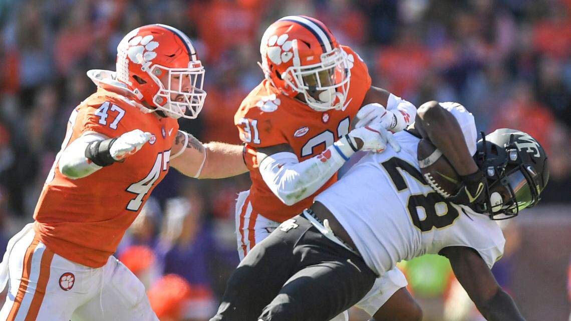Clemson linebacker James Skalski(47) and cornerback Mario Goodrich (31) tackle Wake Forest running back Quinton Cooley during the second quarter of an NCAA college football game Saturday, Nov. 20, 2021, at Memorial Stadium in Clemson, S.C.
