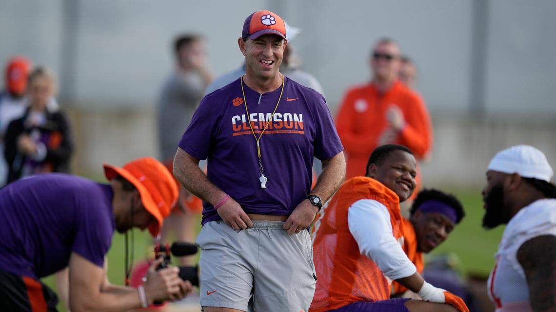 Clemson Tigers head coach Dabo Swinney, center, jokes around with his players as they stretch, during a practice session ahead of the 2022 Orange Bowl, Wednesday, Dec. 28, 2022, in Fort Lauderdale, Fla. Clemson will face the Tennessee Volunteers in the Orange Bowl on Friday, Dec. 30. (AP Photo/Rebecca Blackwell)
