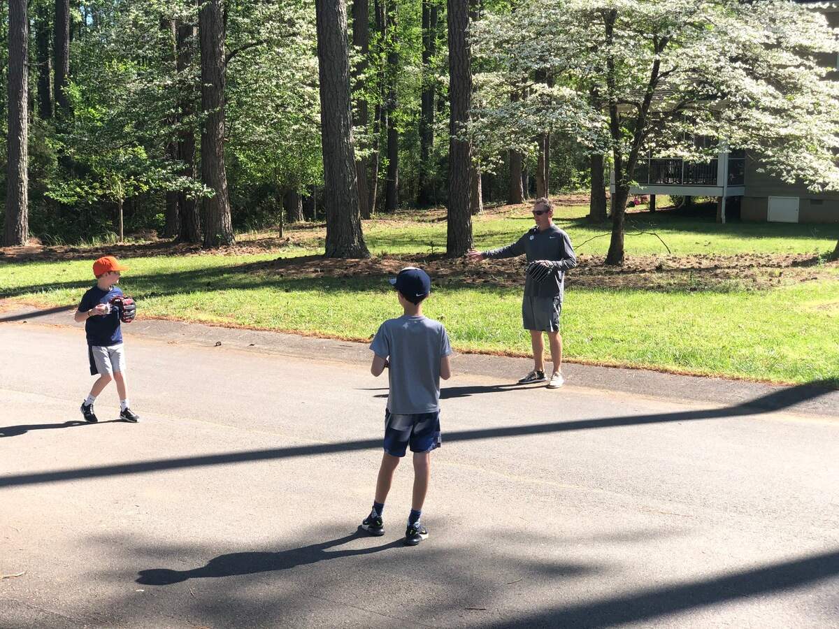 Clemson assistant baseball coach Bradley LeCroy plays catch with sons Cooper (left) and Crew (middle).