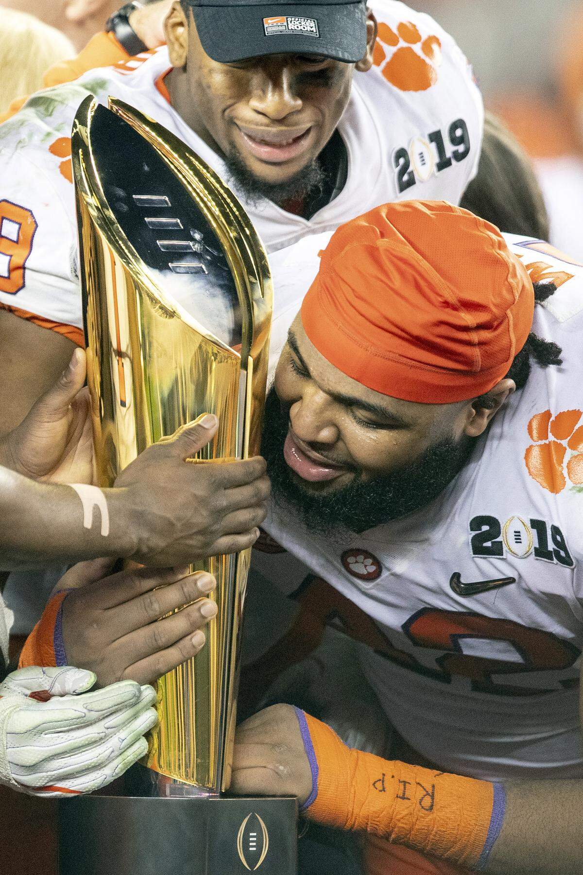 Clemson Tigers defensive lineman Dexter Lawrence takes a close look at the national championship trophy after the win over Alabama.
