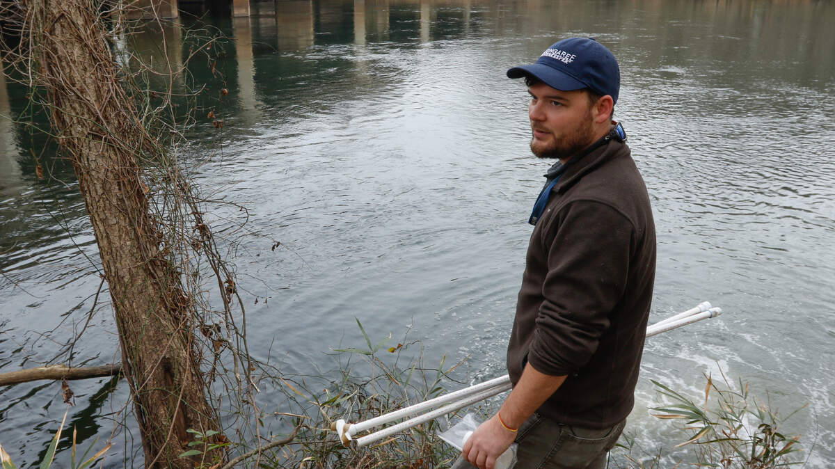 Congaree River Keeper Bill Stangler takes a water sample near one of the five discharge pipes from sewage treatment plants on the Saluda River in 2018. The Saluda River suffered substantially from wet weather in 2021 that caused a series of sewage spills.