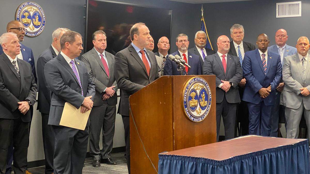 S.C. Attorney General Alan Wilson, center, speaks to reporters about judicial reform on Monday, March 27, 2023, in Columbia, S.C.
