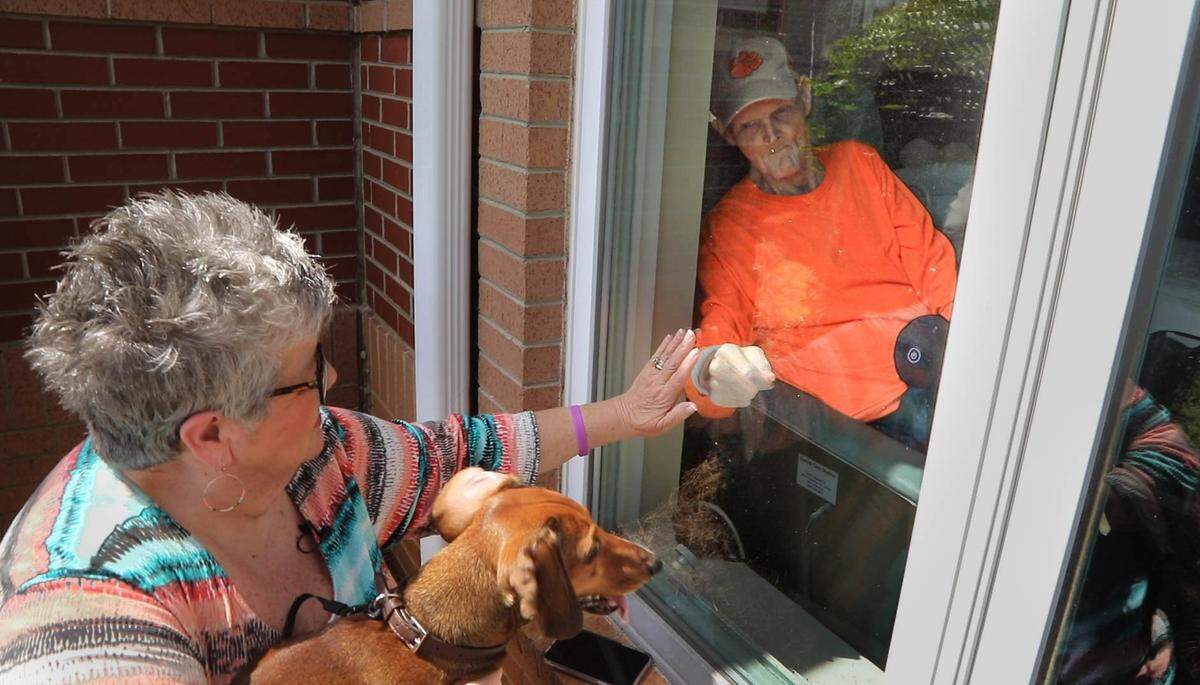 Betti Nix Williams visits her husband, Bill Williams, from outside a window at The Heritage at Lowman in Chapin. The nursing facility is closed to visitors to control the spread of the coronavirus so Williams sits daily outside his window and visits.