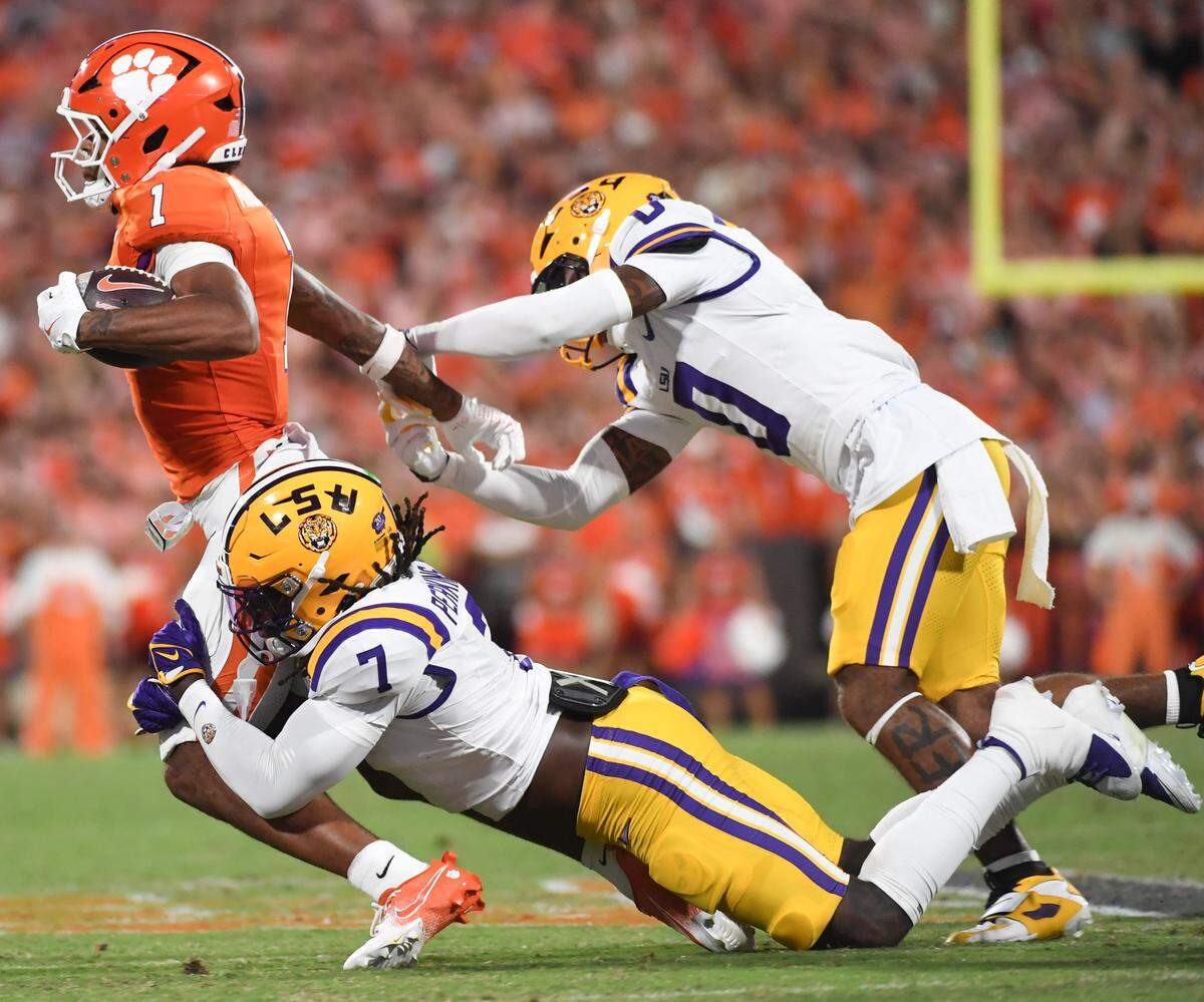 Clemson Tigers wide receiver T.J. Moore (1) is tackled by LSU Tigers linebacker Harold Perkins Jr. (7) and LSU Tigers safety Tamarcus Cooley (0) Saturday, Aug. 30, 2025 during the NCAA football game at Memorial Stadium in Clemson, South Carolina.