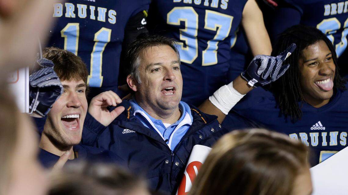 Pulaski Academy coach Kevin Kelley, center, celebrates with his team after the Arkansas Class 5A High School Championship football game in Little Rock, Ark., Saturday, Dec. 6, 2014. Pulaski Academy defeated Wynne High School 38-28. (AP Photo/Danny Johnston)