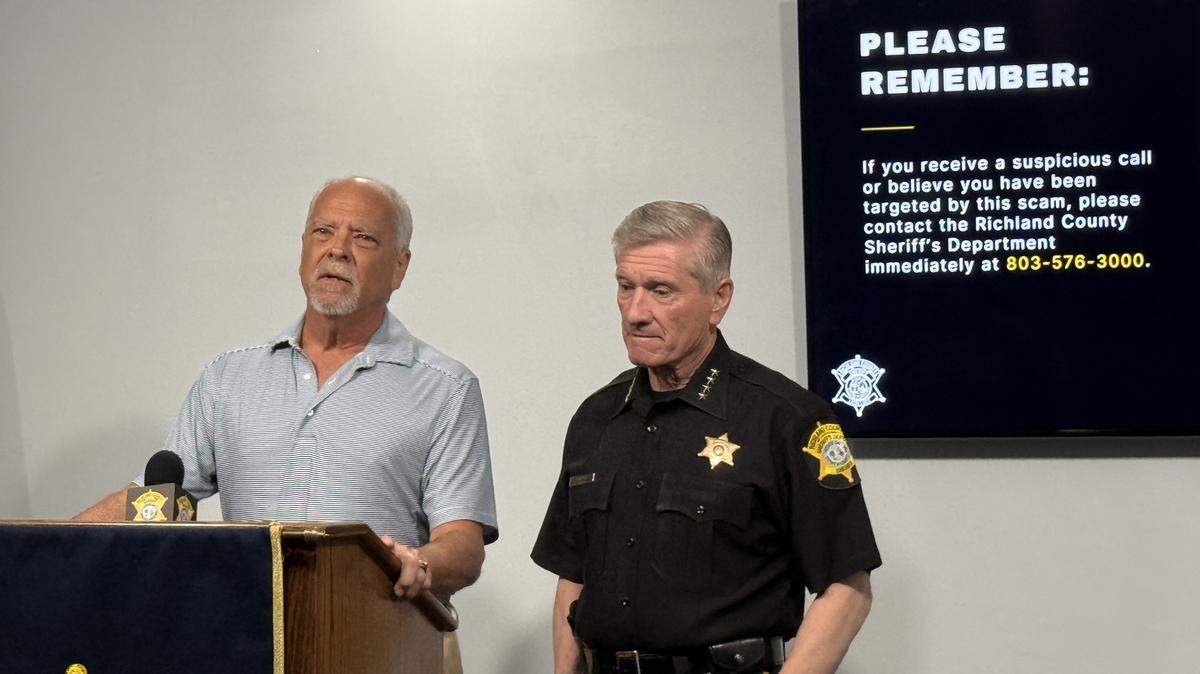 Arthur Monk (left), victim of a ruthless telephone scam that played on his emotions, stands with Richland County Sheriff Leon Lott to tell reporters about his experience.