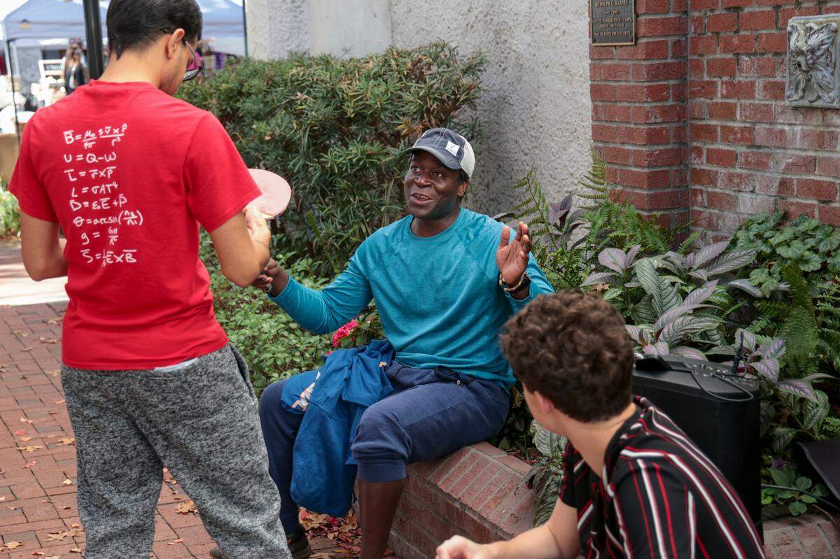 Komi Tepe, center talks with ping pong enthusiasts, Priyansh Joshi, left, and Joseph Dewey in downtown Columbia. An outdoor ping pong table has been added to the pocket park next to the Tapps building in downtown Columbia.