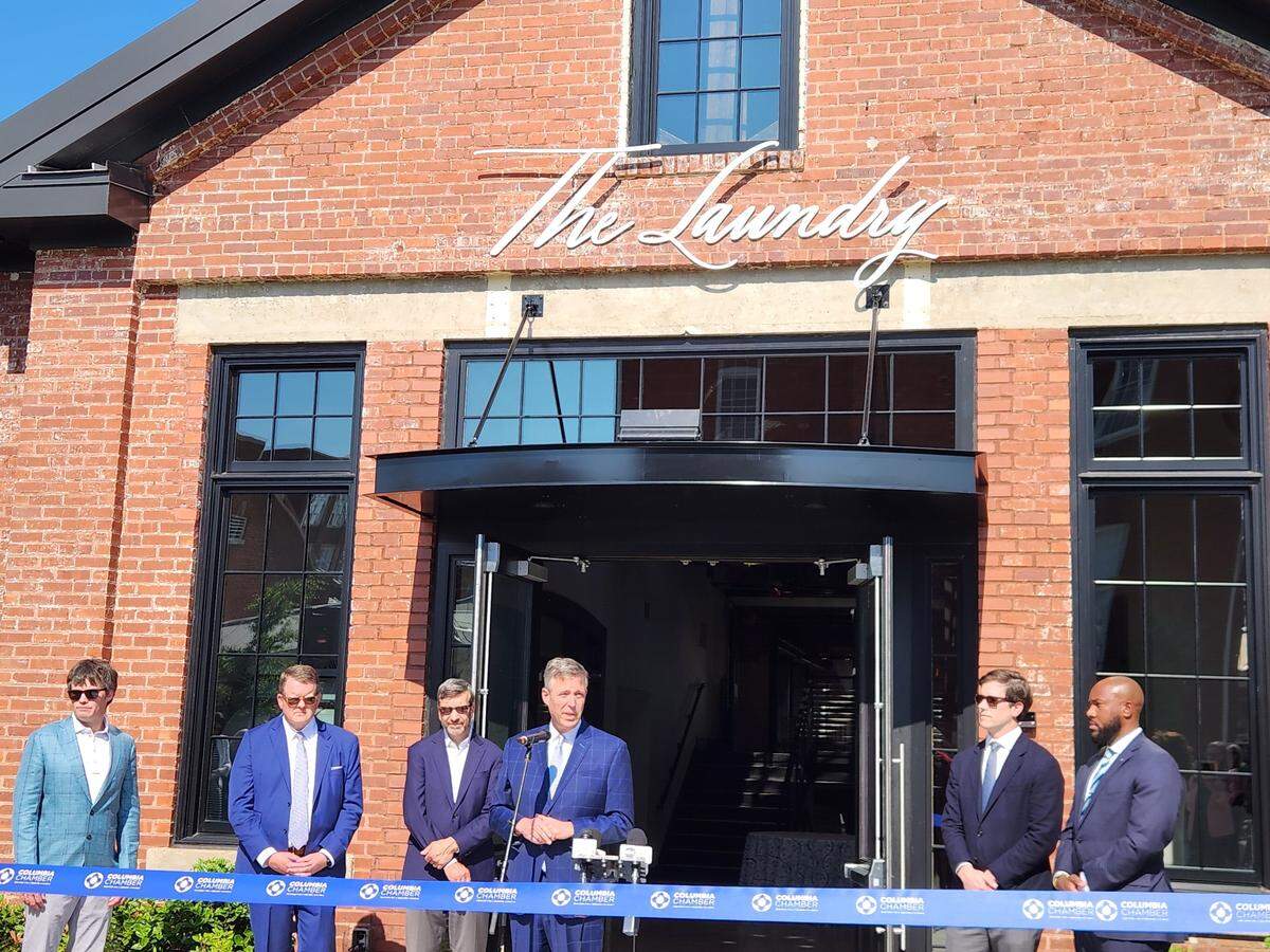 Columbia Mayor Daniel Rickenmann, center, speaks on April 9, 2025 at the ribbon cutting ceremony The Laundry, a new event venue at the BullStreet District.