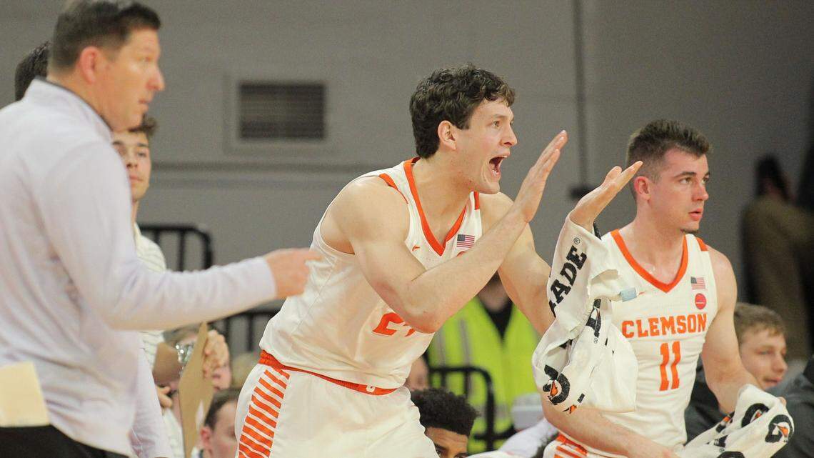 Clemson center PJ Hall (24) cheers on his team against Florida State during first-half action in Clemson, S.C. on Saturday, Feb. 24, 2024. Hall was pulled to the bench by Brad Brownell, at left, for getting into early foul trouble. At right is Clemson guard Joseph Girard III (11).
