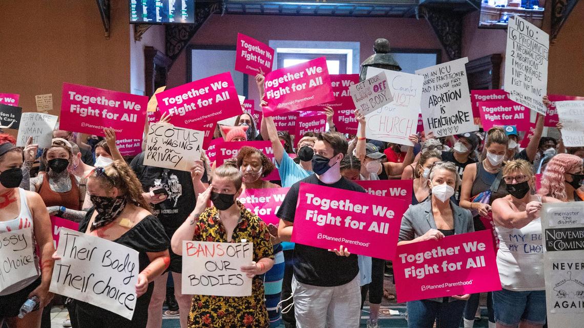 Protesters who support abortion access hold signs in the South Carolina State House lobby on Tuesday, June 28, 2022.