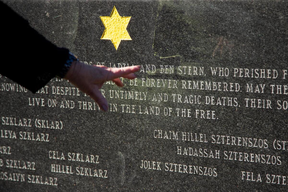 Dr. Lilly Filler gestures at a memorial for victims of the Holocaust and Filler’s family who survived the Holocaust at Beth Shalom Cemetery on Thursday, December 10, 2020. Whenever she comes to visit the grave, she notices more stones left on top, a traditional way to honor the dead in Judaism.