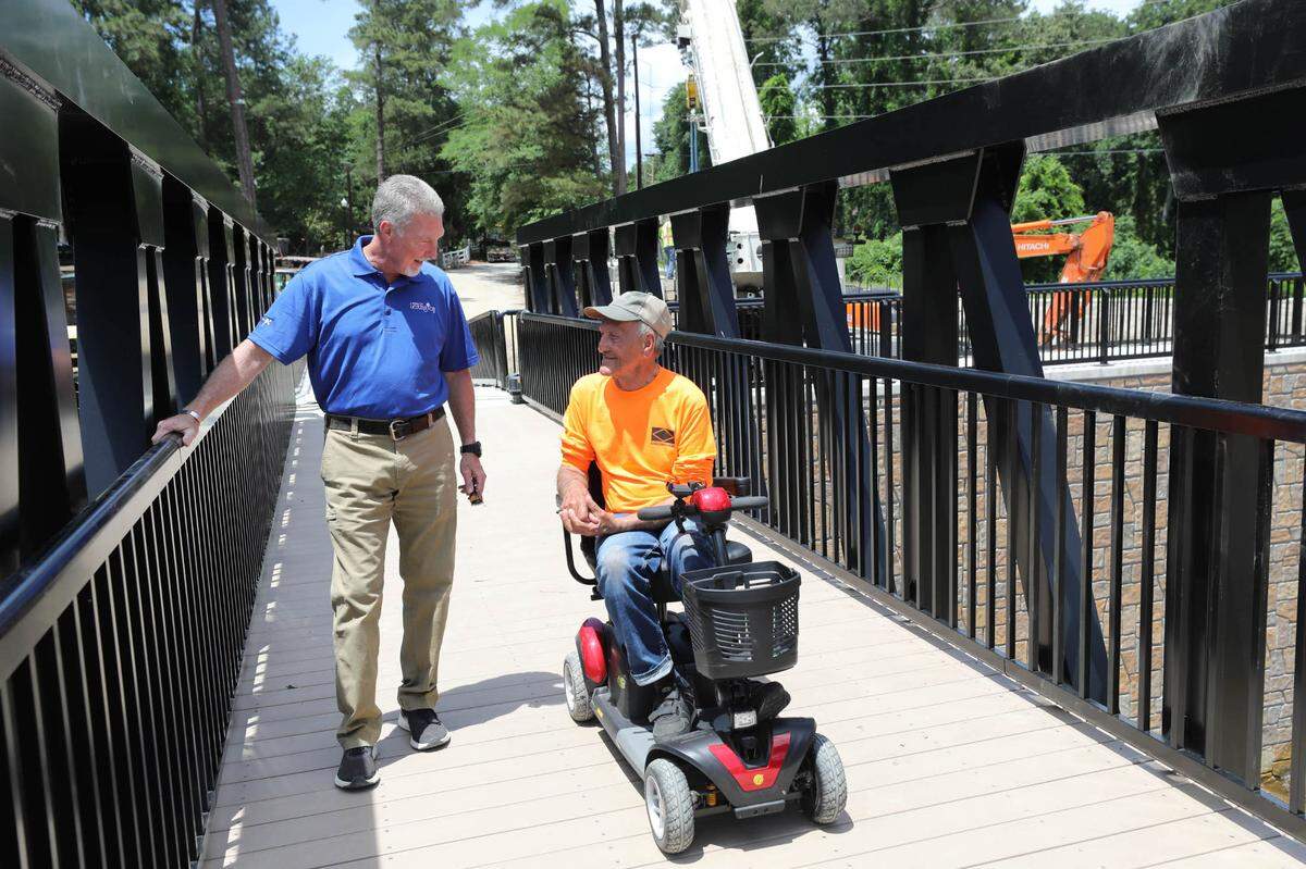 Lexington Mayor Steve MacDougall visits with Jim Farnham after crossing the new pedestrian bridge at Gibson Pond Park in Lexington. Farnham visits the construction site daily to watch the progress.
