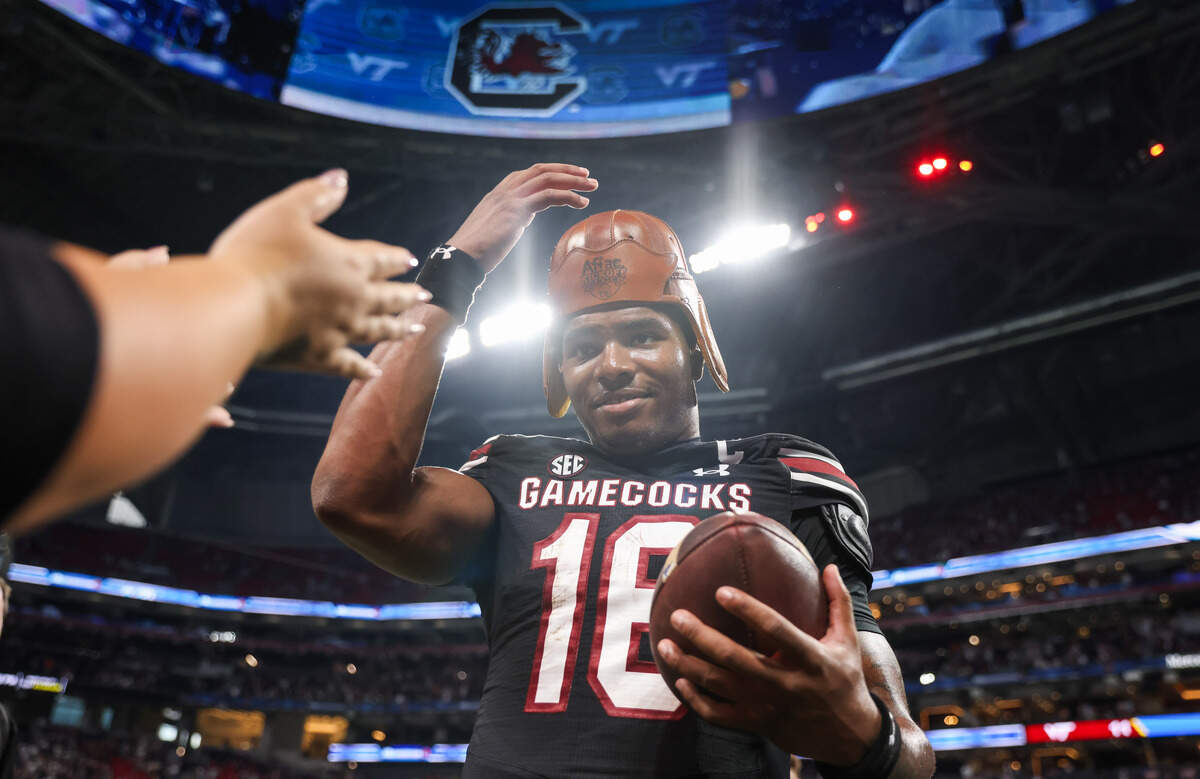 South Carolina quarterback LaNorris Sellers (16) puts on the leather helmet trophy Sunday at Mercedes-Benz Stadium in Atlanta. The Gamecocks and Hokies faced off Aug. 31 in the 2025 Aflac Kickoff Game.
