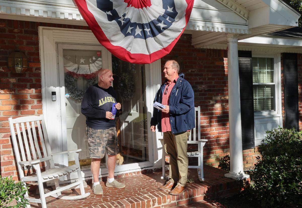 Republican candidate for Senate district 26, Jason Guerry talks with Mike Valk while campaigning in the Whitehall neighborhood on Friday, Oct. 18, 2024.