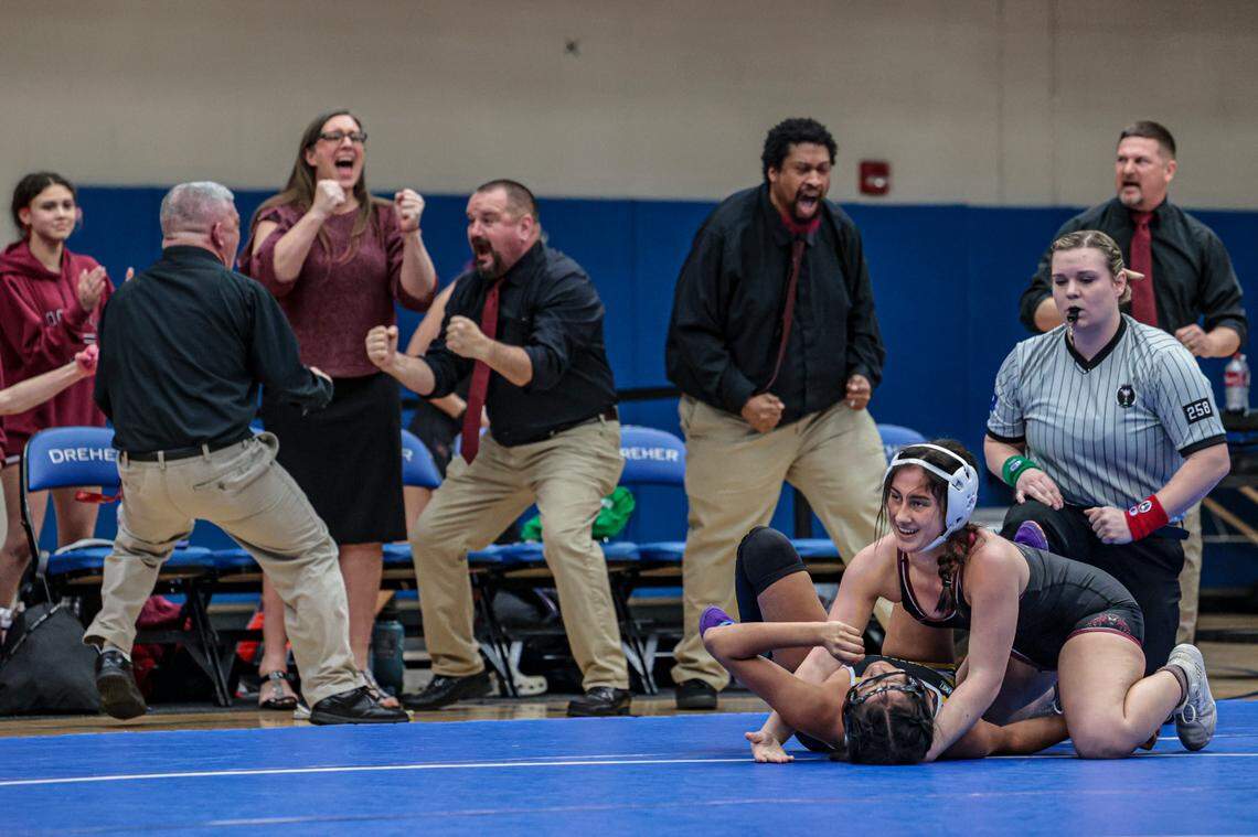 Rock Hill coaches, from left, Cain Beard, Kim Manning, Scooter Weather, Anthony Thomas and Eddie Cook, react as Maggie Cogar pins Greenwood’s Sophia Ricardo to win the 130-pound weight class during the Class 5A state championships at Dreher High School on Saturday, Feb. 8 2025.