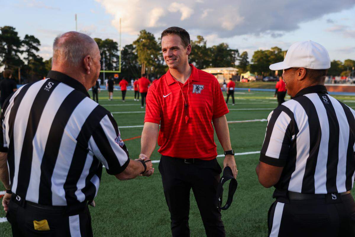 Nation Ford head coach Jake Bentley meets with officials before the team’s game against Richland Northeast in Columbia on Sept. 11.