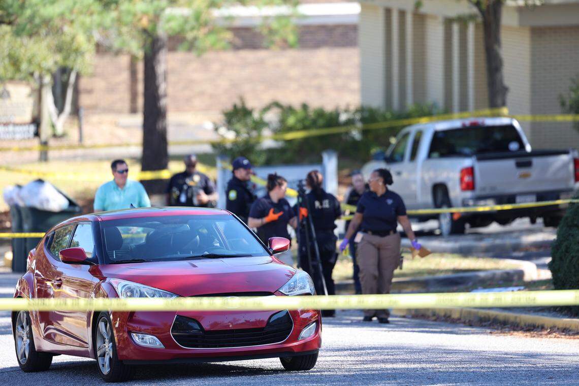 Police tape surrounds a red car Friday as police investigate a shooting incident at Middleburg Plaza, which reportedly happened in a parking lot adjacent to Planned Parenthood.