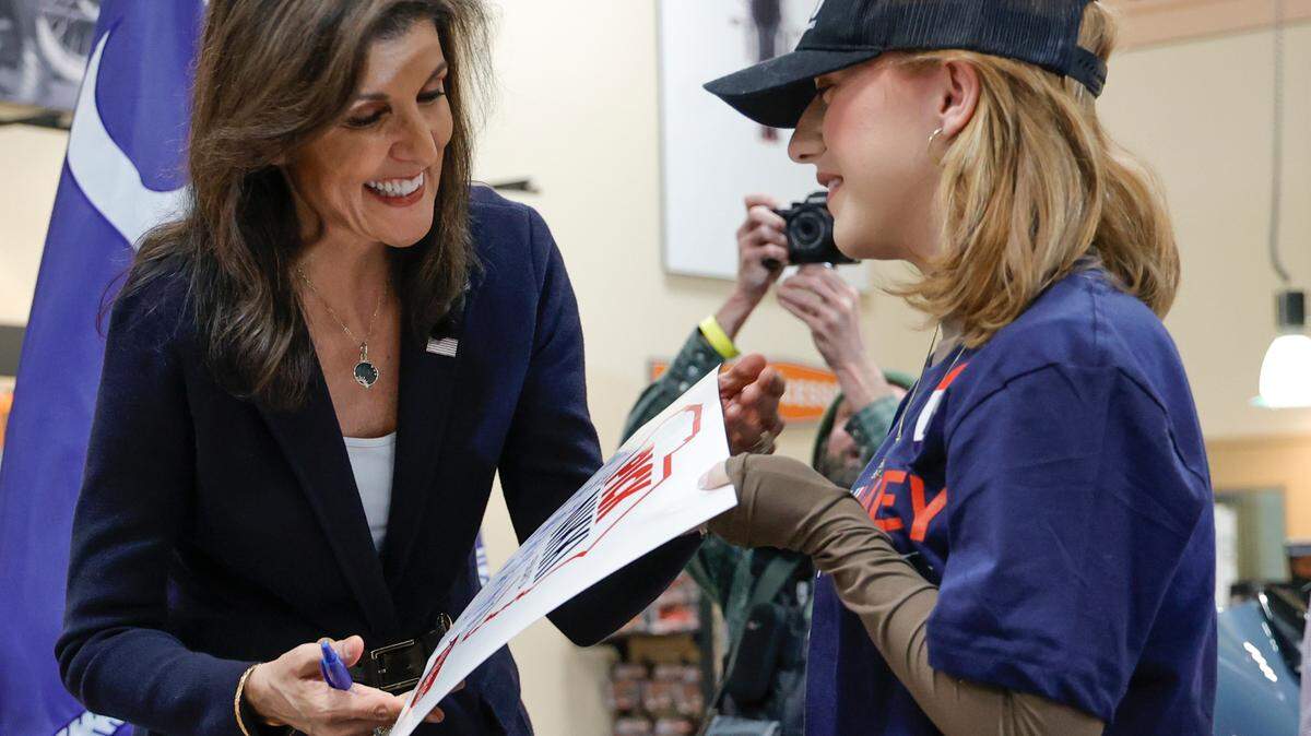 Candidate fort U.S. President, Nikki Haley signs a poster for Shanlyn Todd during a campaign rally at Thunder Tower Harley Davidson in Pontiac on Monday, Feb. 12, 2024. The note on the poster was an excuse for Shanlyn missing government class to attend the rally.