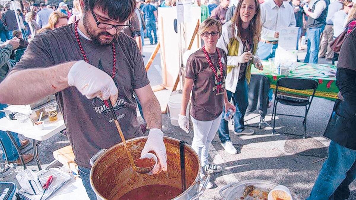 Members of the Blazing Saddles Chili Company ladle samples of their chili during last year’s Five Points Chili Cook Off. This year’s event kicks off at noon on Nov. 3.