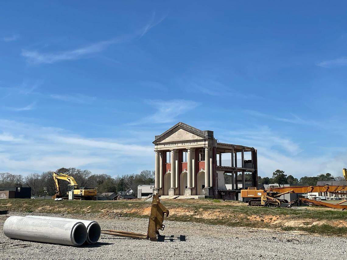 The wings of the historic Williams Building at BullStreet have been demolished, leaving only the center facade standing starkly amid future construction sites on either side. Pictured in March 2021.