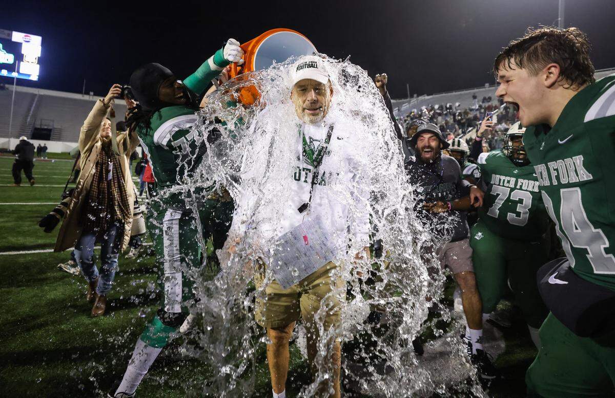 Dutch Fork head coach Tom Knotts is doused with water following his team’s win in the SCHSL Class 5A Division I championship game between Dutch Fork and Summerville at Oliver C. Dawson Stadium in Orangeburg on Saturday.